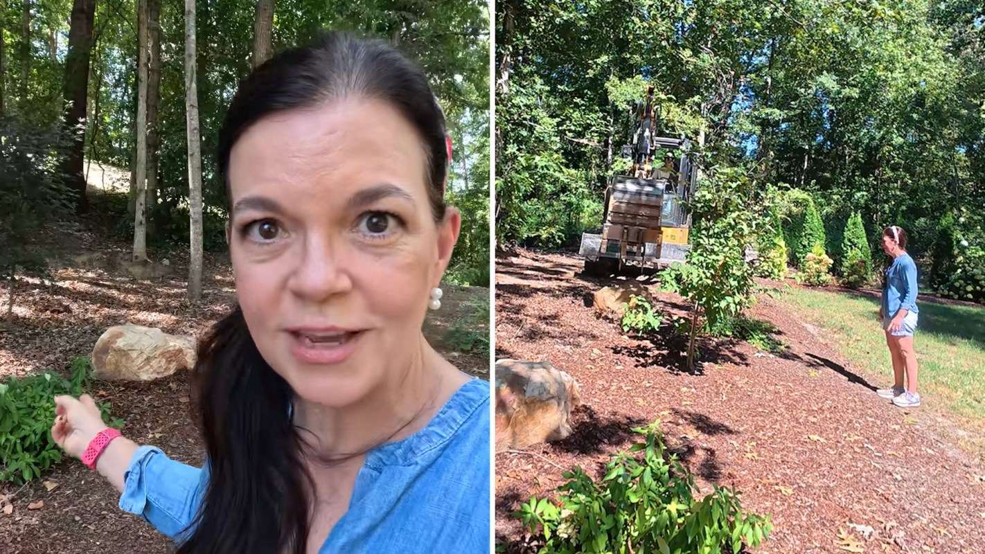 A woman points towards a landscaping area with a machine and another person in the background.
