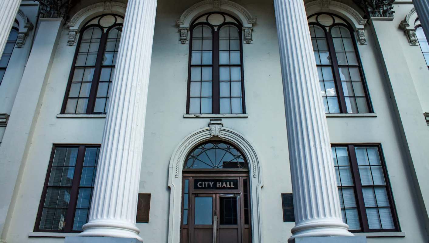 A building exterior featuring columns and a door labeled "CITY HALL."