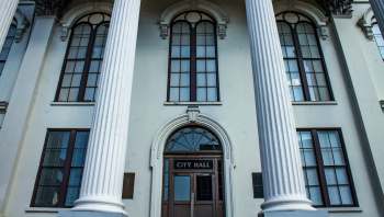 A building exterior featuring columns and a door labeled "CITY HALL."