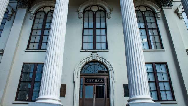 A building exterior featuring columns and a door labeled "CITY HALL."