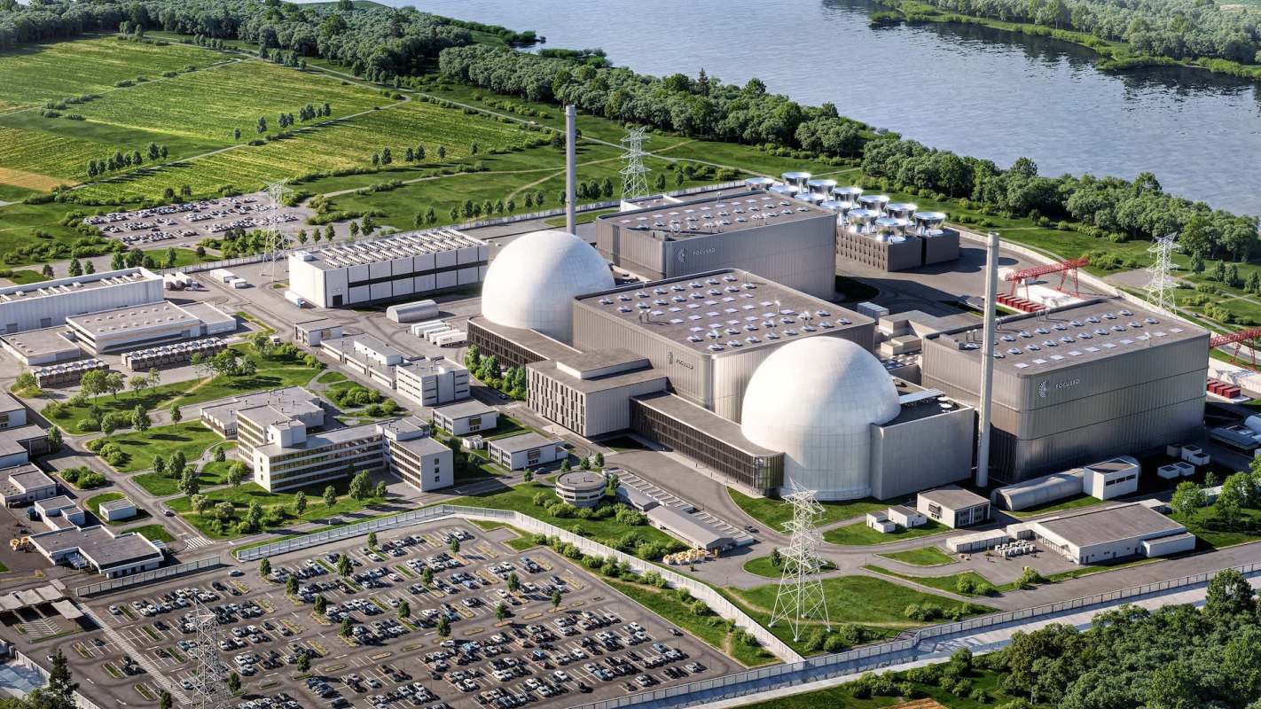 Aerial view of a nuclear power plant with storage buildings and a nearby river.