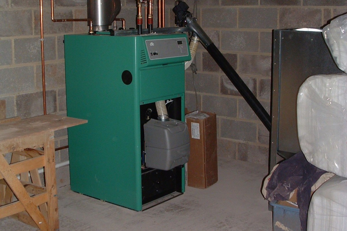 A green oil boiler in a concrete basement