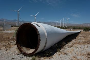 A wind turbine lying down in front of other wind turbines.