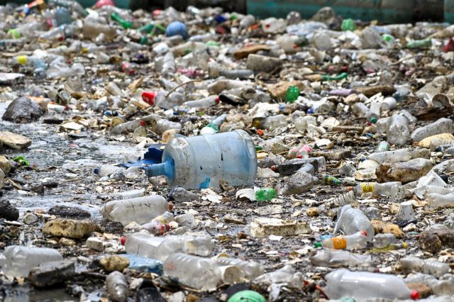 A large amount of plastic pollution with a water jug in the middle