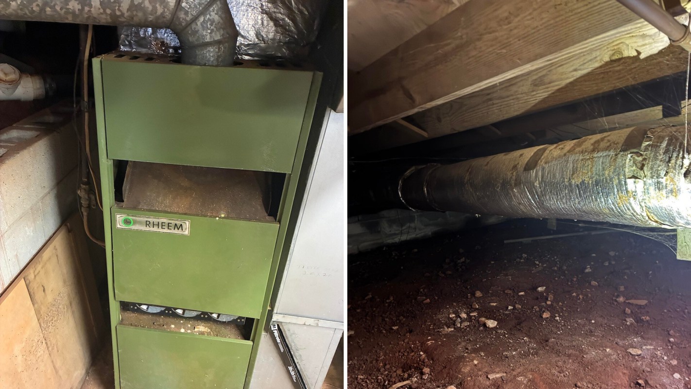 A green heating unit next to a duct in a basement environment.