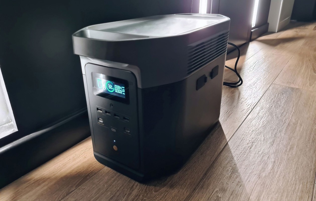 A portable generic brand power station sits on a wooden floor inside a home