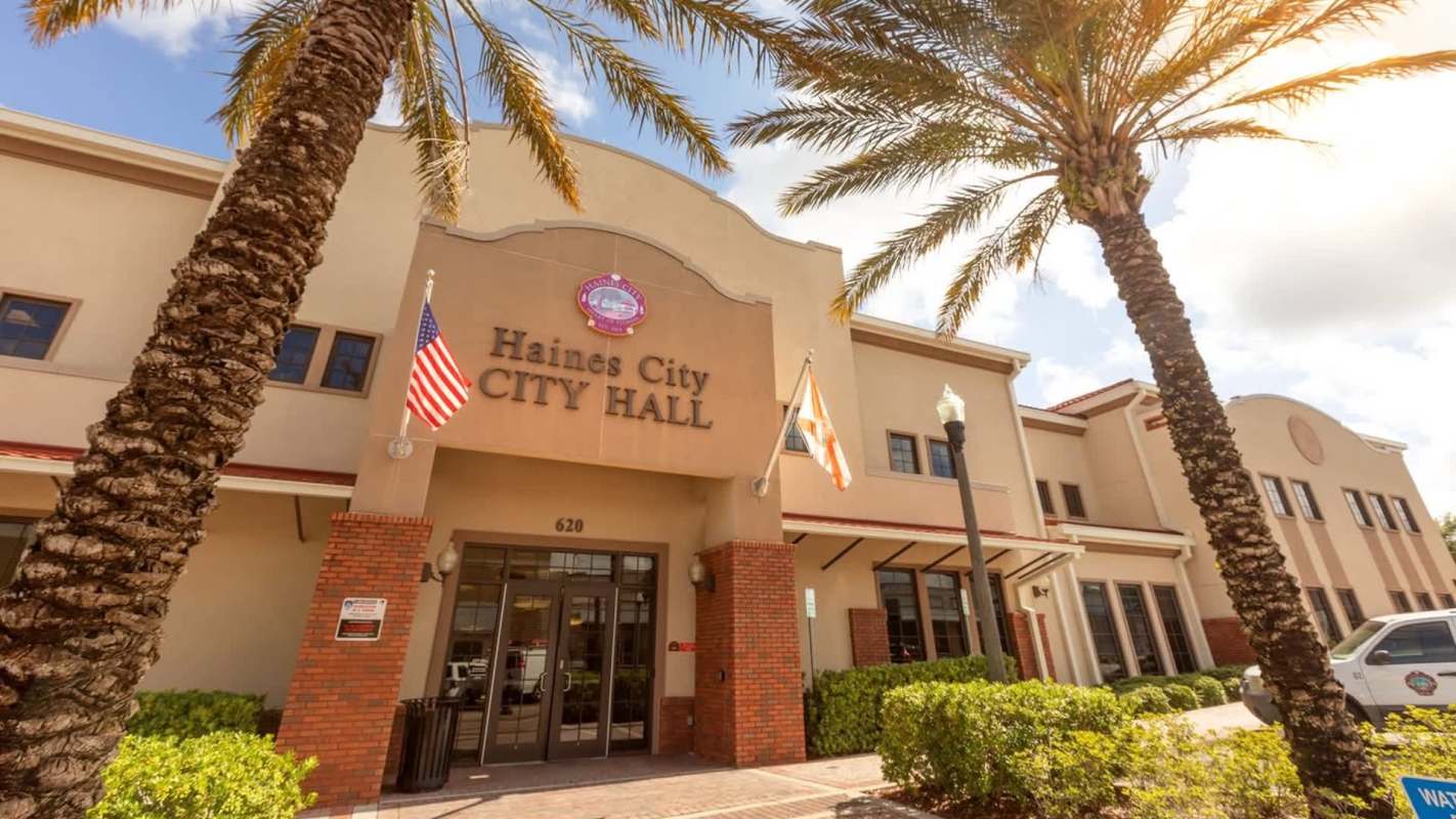 Haines City City Hall building with palm trees and flags outside.