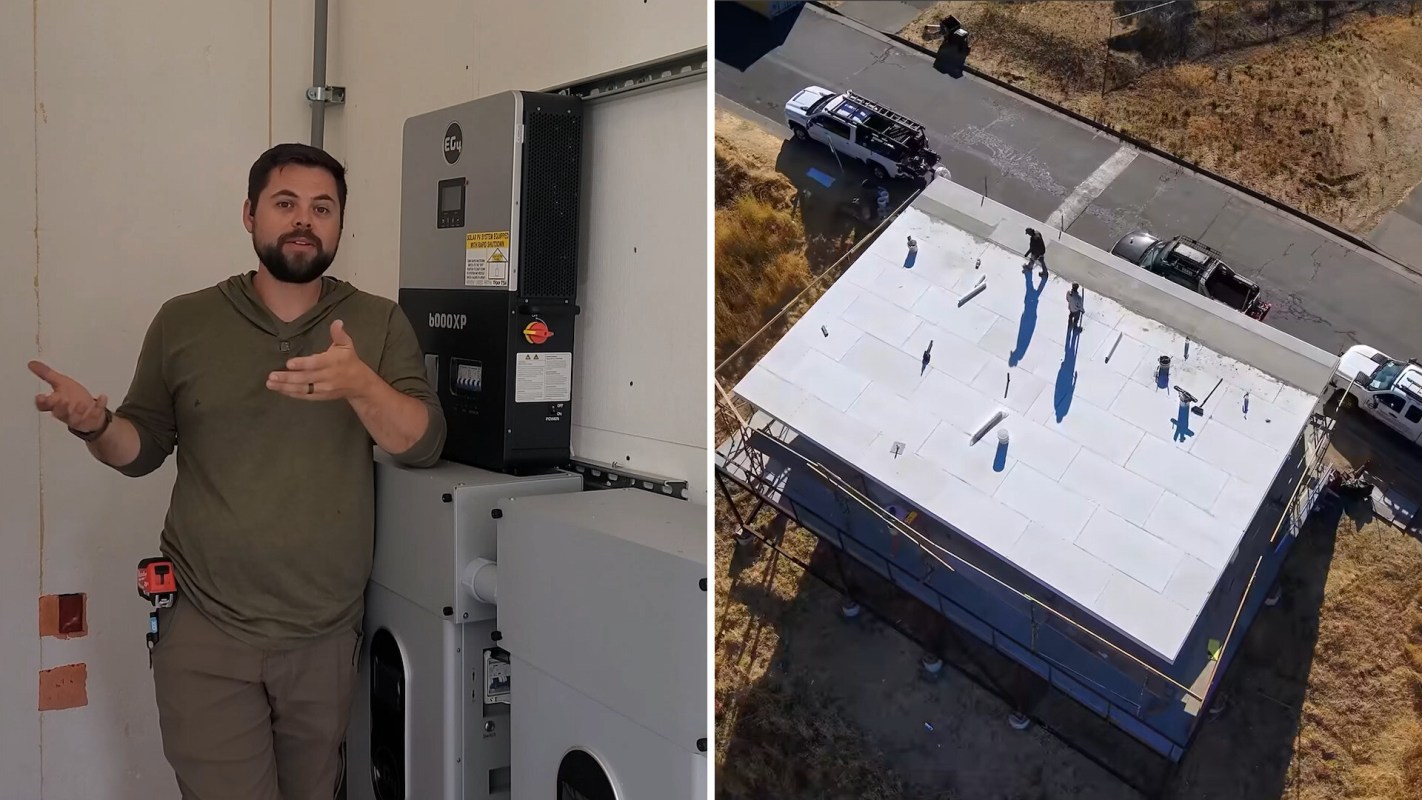A man stands next to electrical equipment, while workers are visible on a roof in the background.