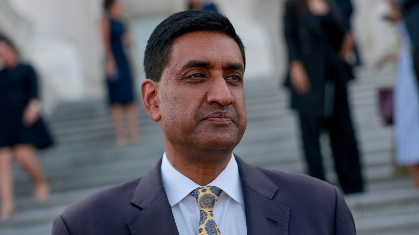 California Rep. Ro Khanna stands on steps with people in the background.