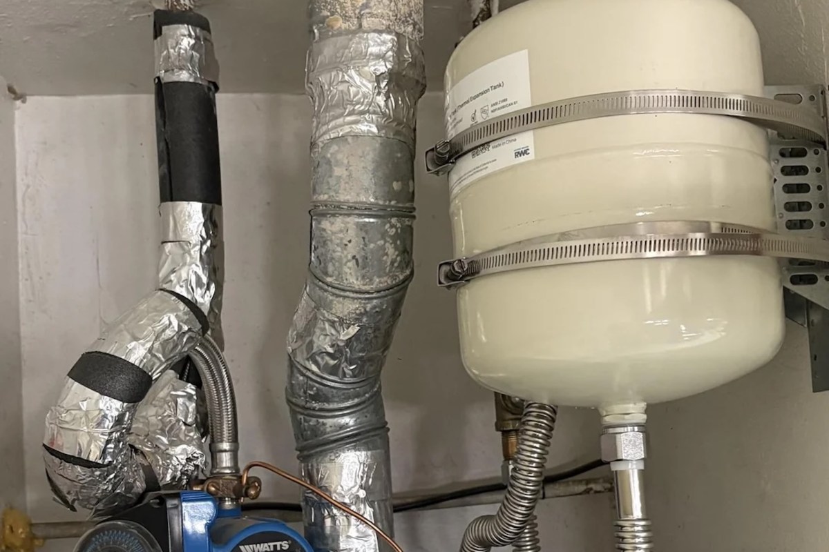An expansion tank and pipes connected to a water heater.