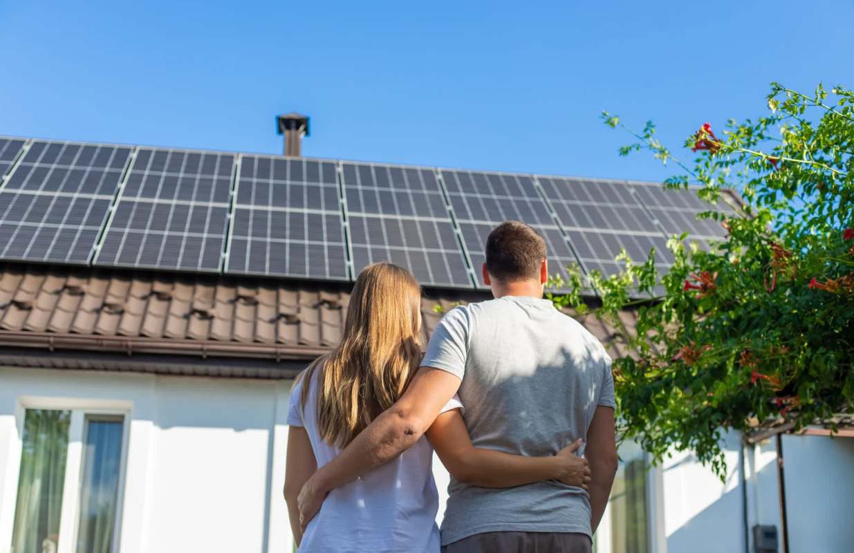People looking at solar panels on a home.
