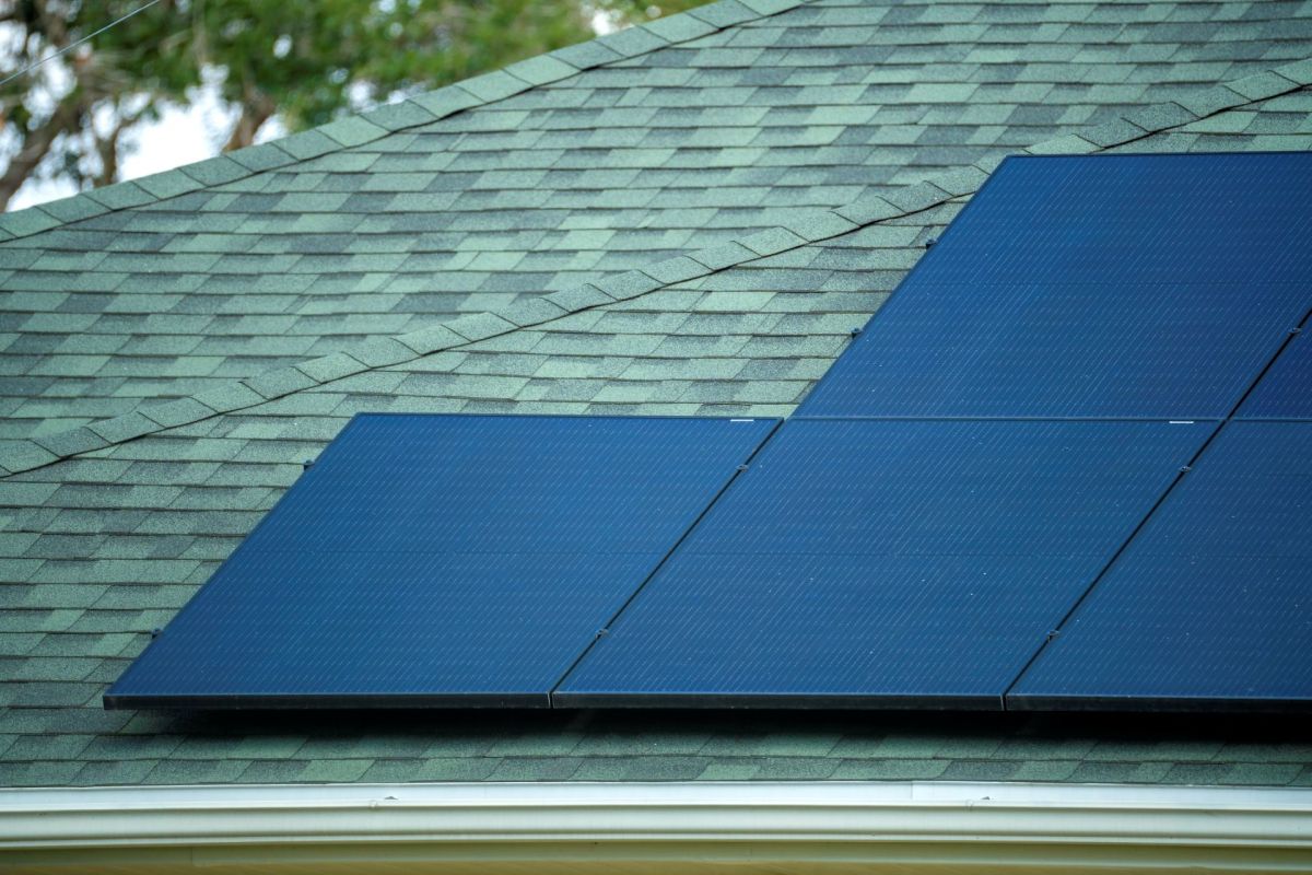 Several solar panels sit on the roof of a house