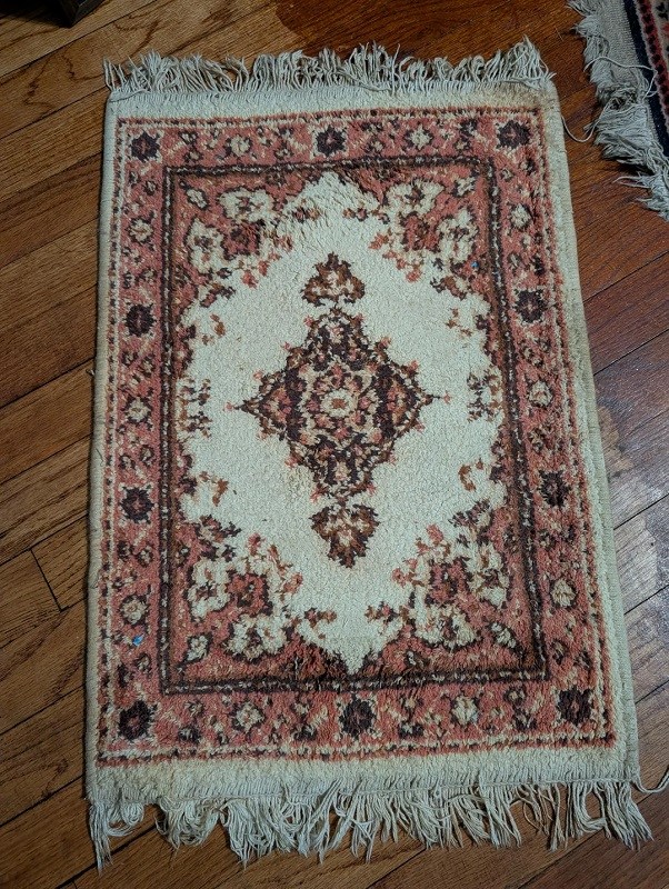 A colorful rug laid out on a wooden floor