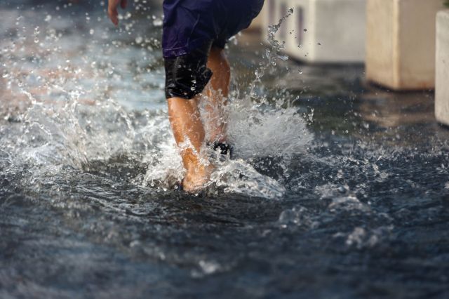 A person running on a flooded road.