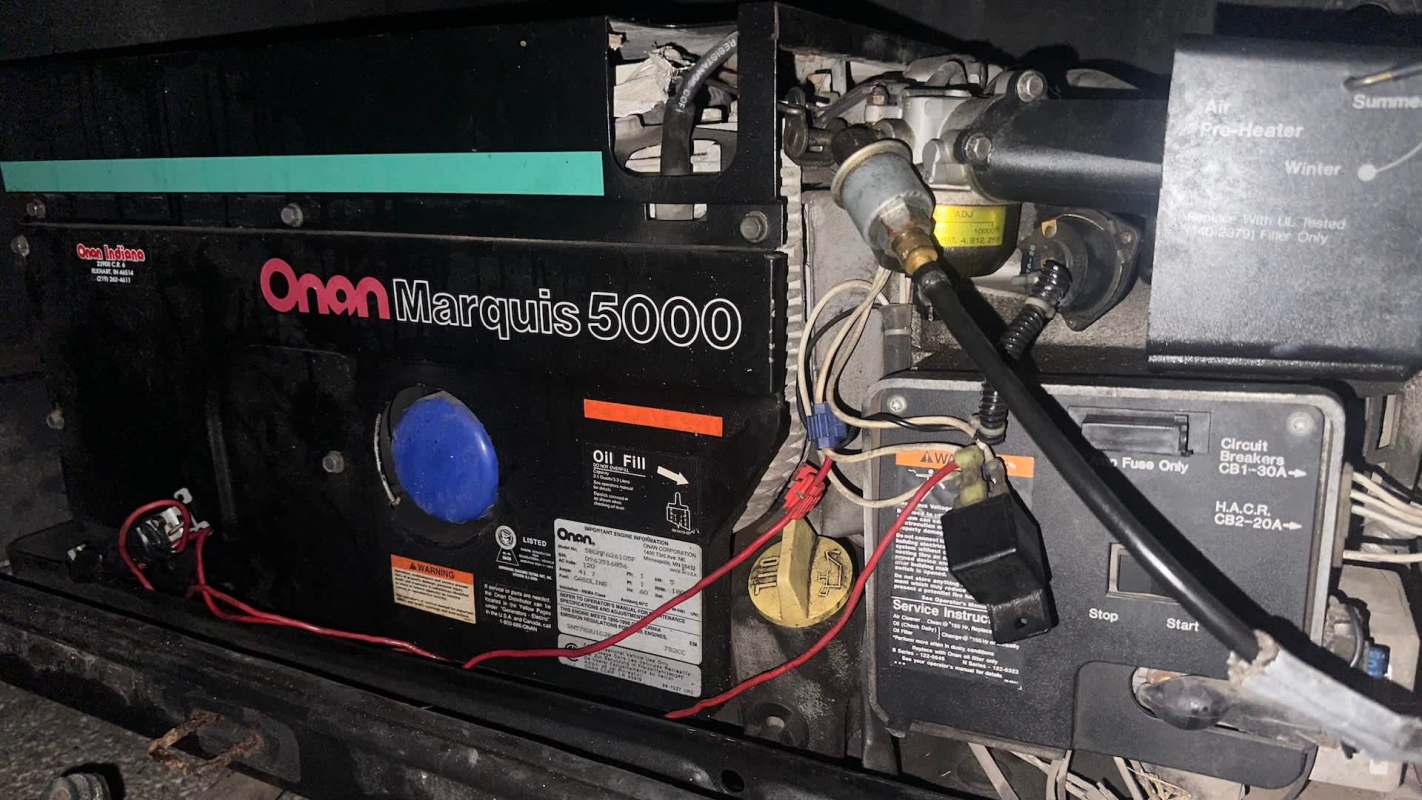 An Onan Marquis 5000 generator with various components and wiring visible.