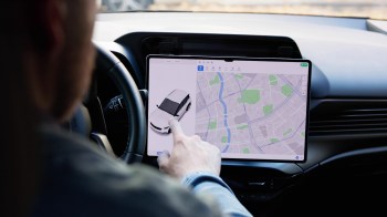 A person using a car's touchscreen.