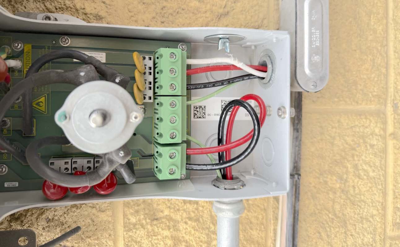 An electrical box with various wires, connectors, and components visible inside.