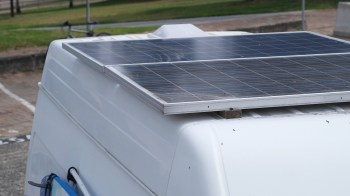 A solar panel installed on the roof of a white vehicle.