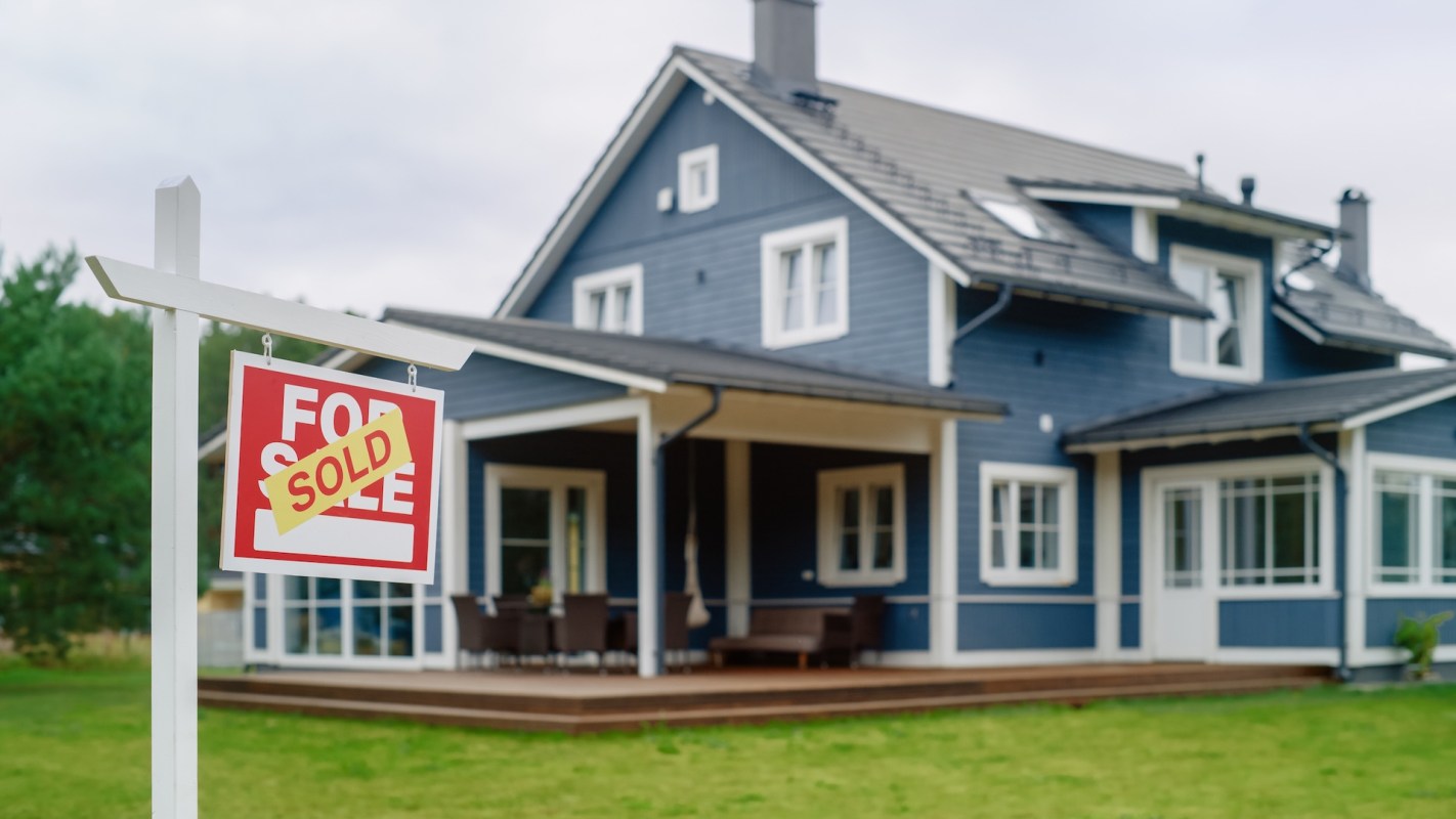 A house with a "Sold" sign in front of it.