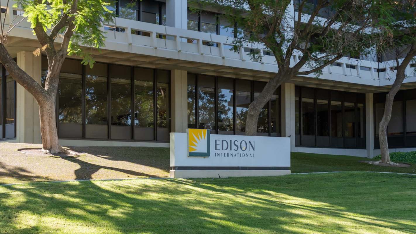 A sign for Edison International in front of a modern building with trees and grass.