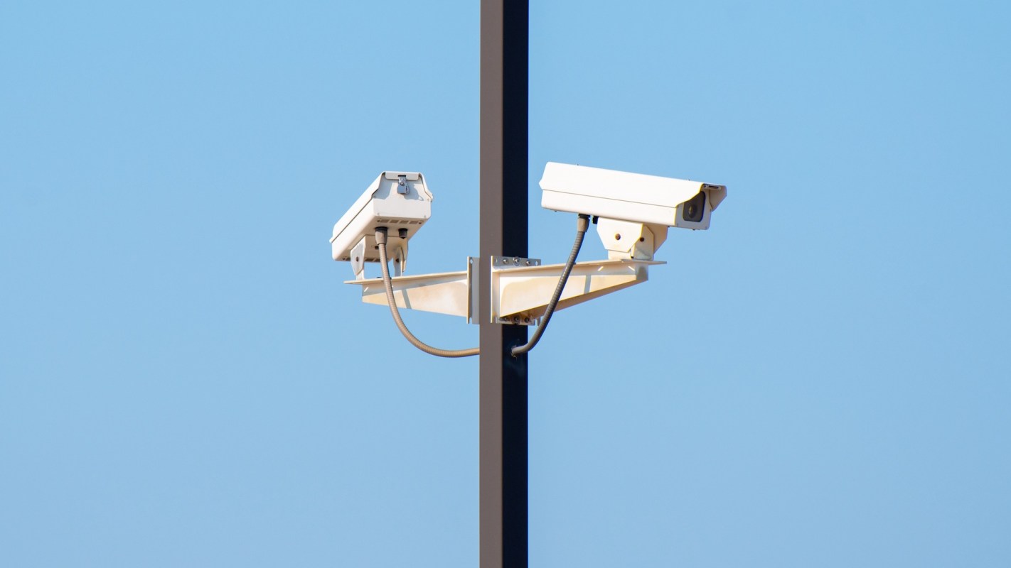 Two surveillance cameras mounted on a pole.