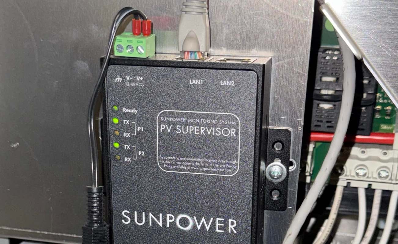 A SunPower PV Supervisor monitoring system with indicator lights and connected wires.