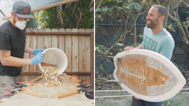A person in a mask pours materials from a bucket, while another person holds a decorated surfboard.
