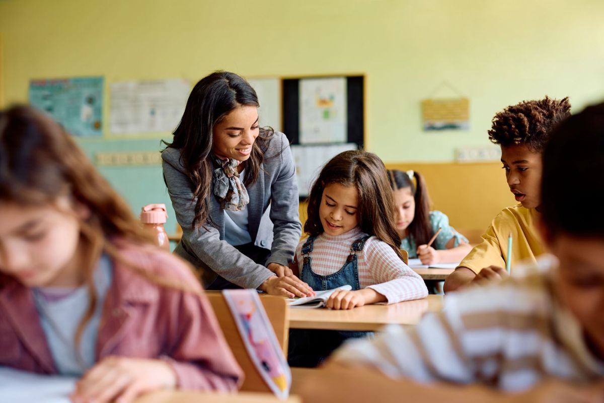 A teacher helping a student in a classroom.