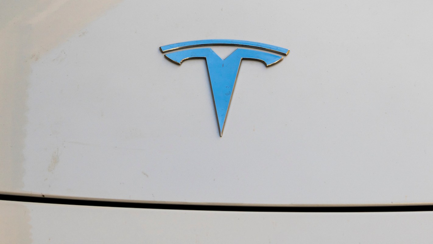 A Tesla logo on a white surface.