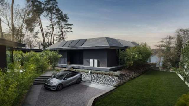 A modern house with solar panels surrounded by greenery and a parked electric car.