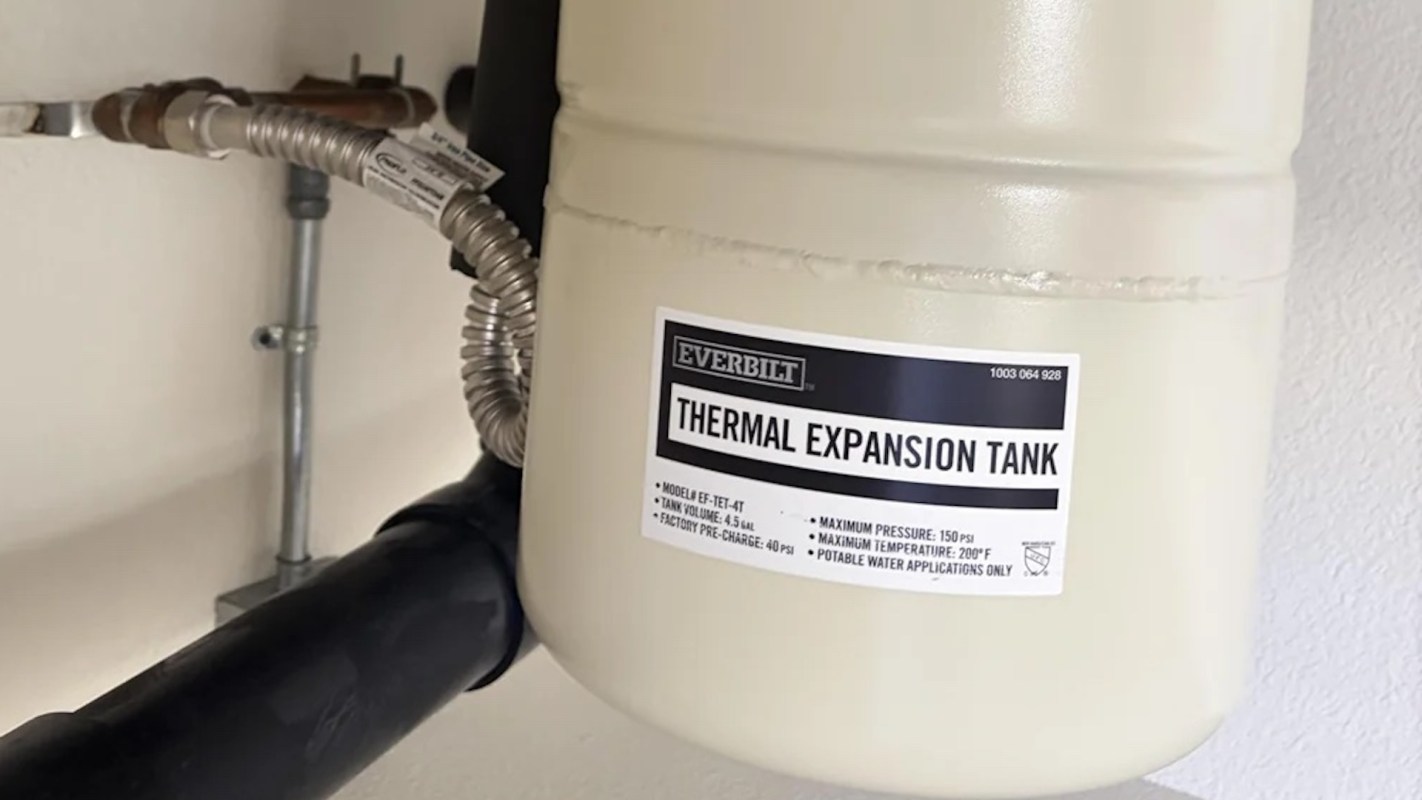 A thermal expansion tank mounted on a wall with a label detailing its specifications.