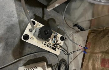 A disassembled device with wires and a small motor on a concrete floor.