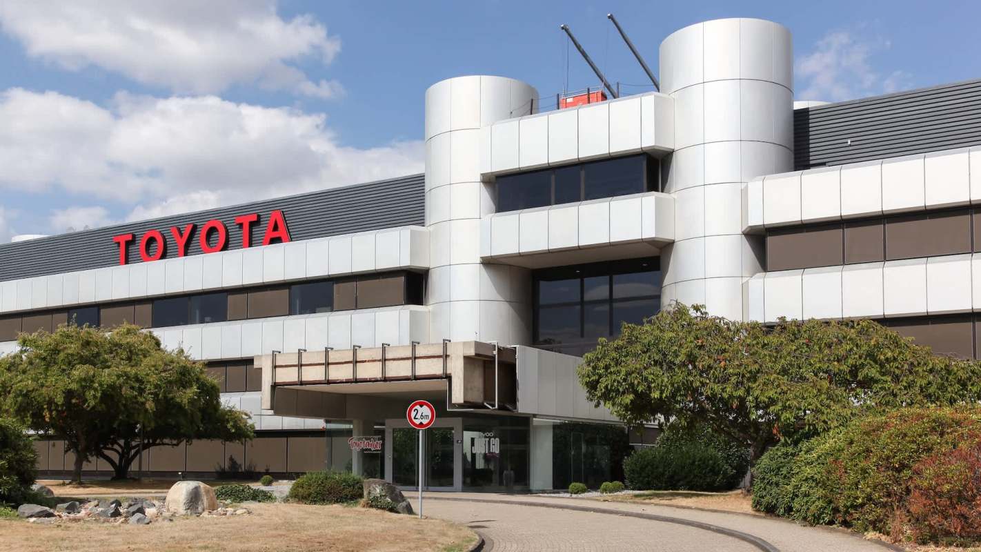 A modern building with the Toyota logo and landscaped greenery in front.