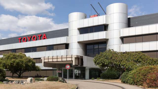 A modern building with the Toyota logo and landscaped greenery in front.