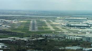 An aerial view of Heathrow Airport with runways, taxiways, and parked aircraft.