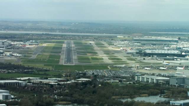An aerial view of Heathrow Airport with runways, taxiways, and parked aircraft.