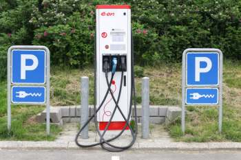 An electric vehicle charging station with two signage posts.