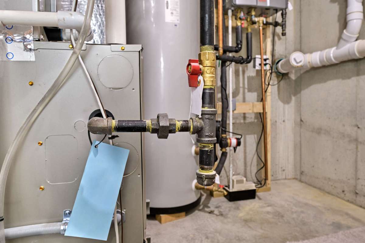 A plumbing setup featuring various pipes and valves in a basement.
