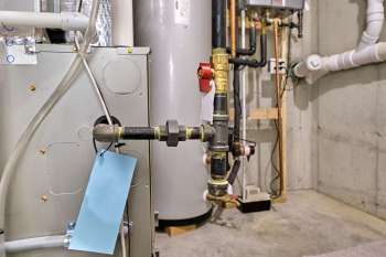 A plumbing setup featuring various pipes and valves in a basement.