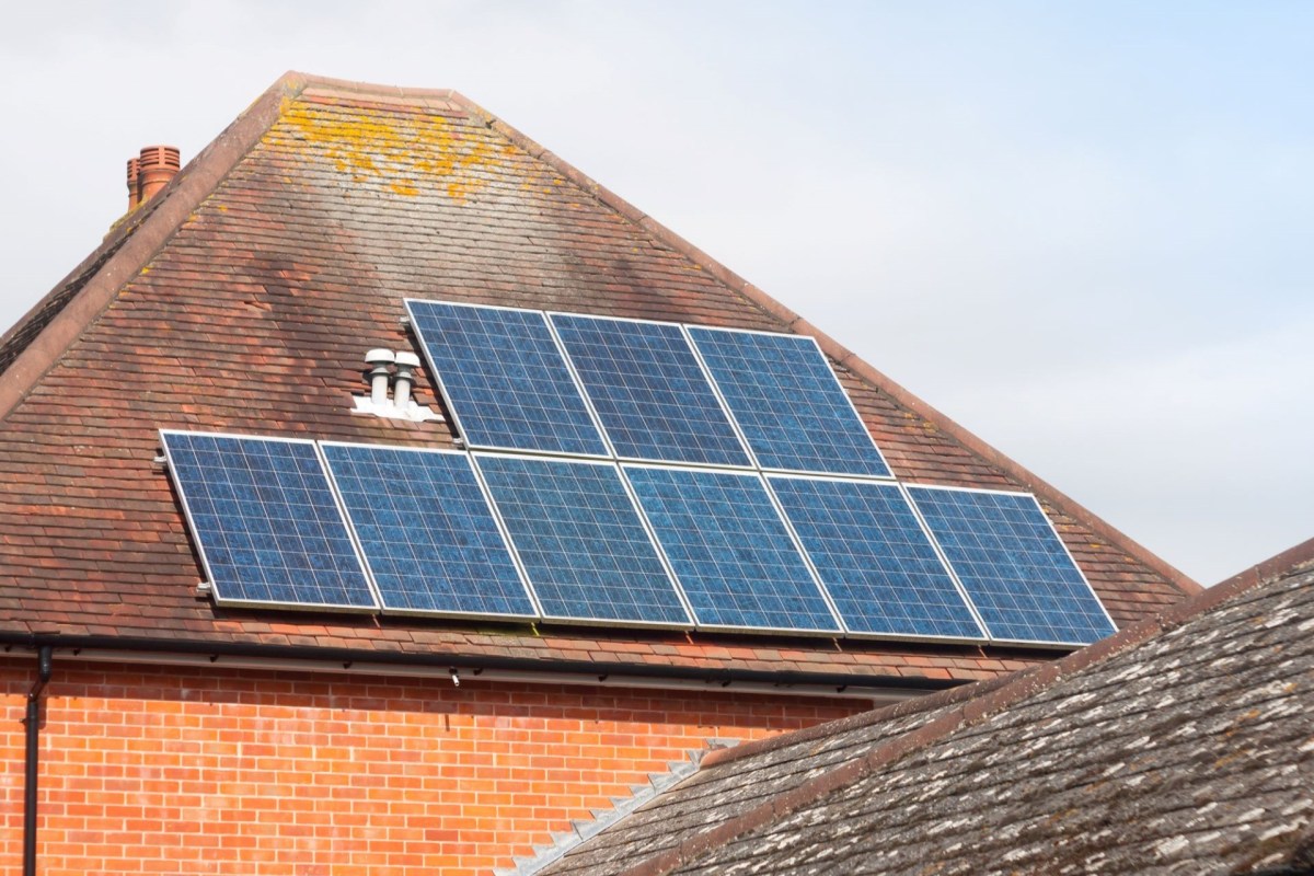 Solar panels installed on a brown tiled roof of a building.