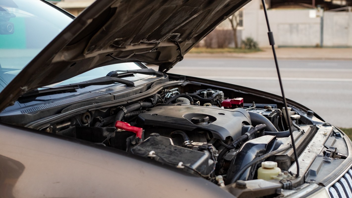 An open car hood revealing the engine and various components.
