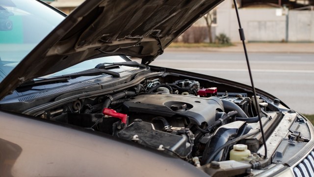 An open car hood revealing the engine and various components.