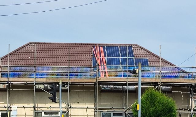 An unfinished solar panel installation on a roof.