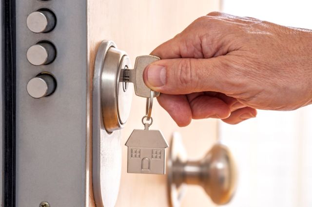 A person unlocking a front door.