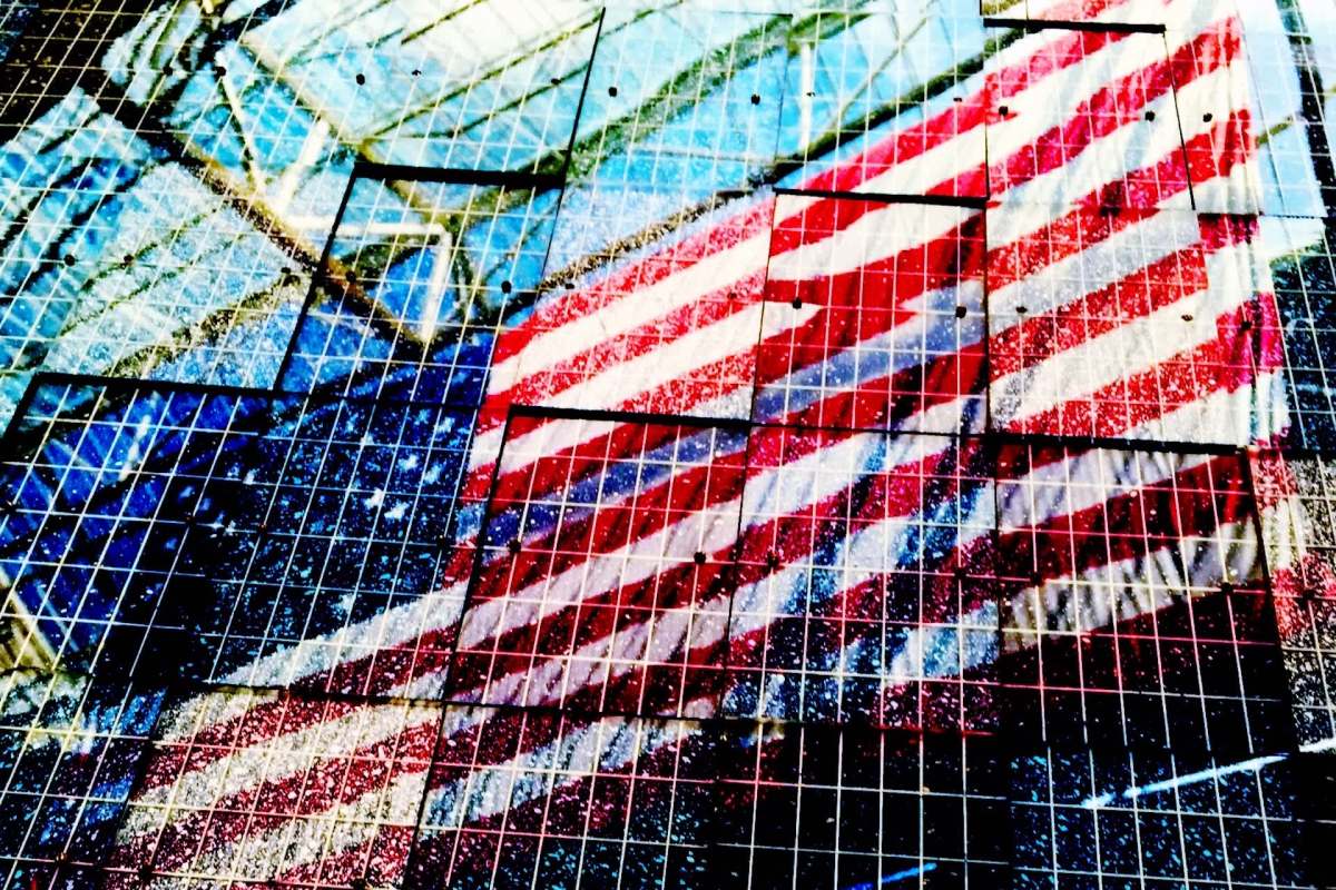 A reflection of an American flag on solar panels.