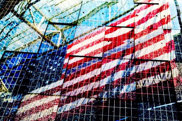 A reflection of an American flag on solar panels.