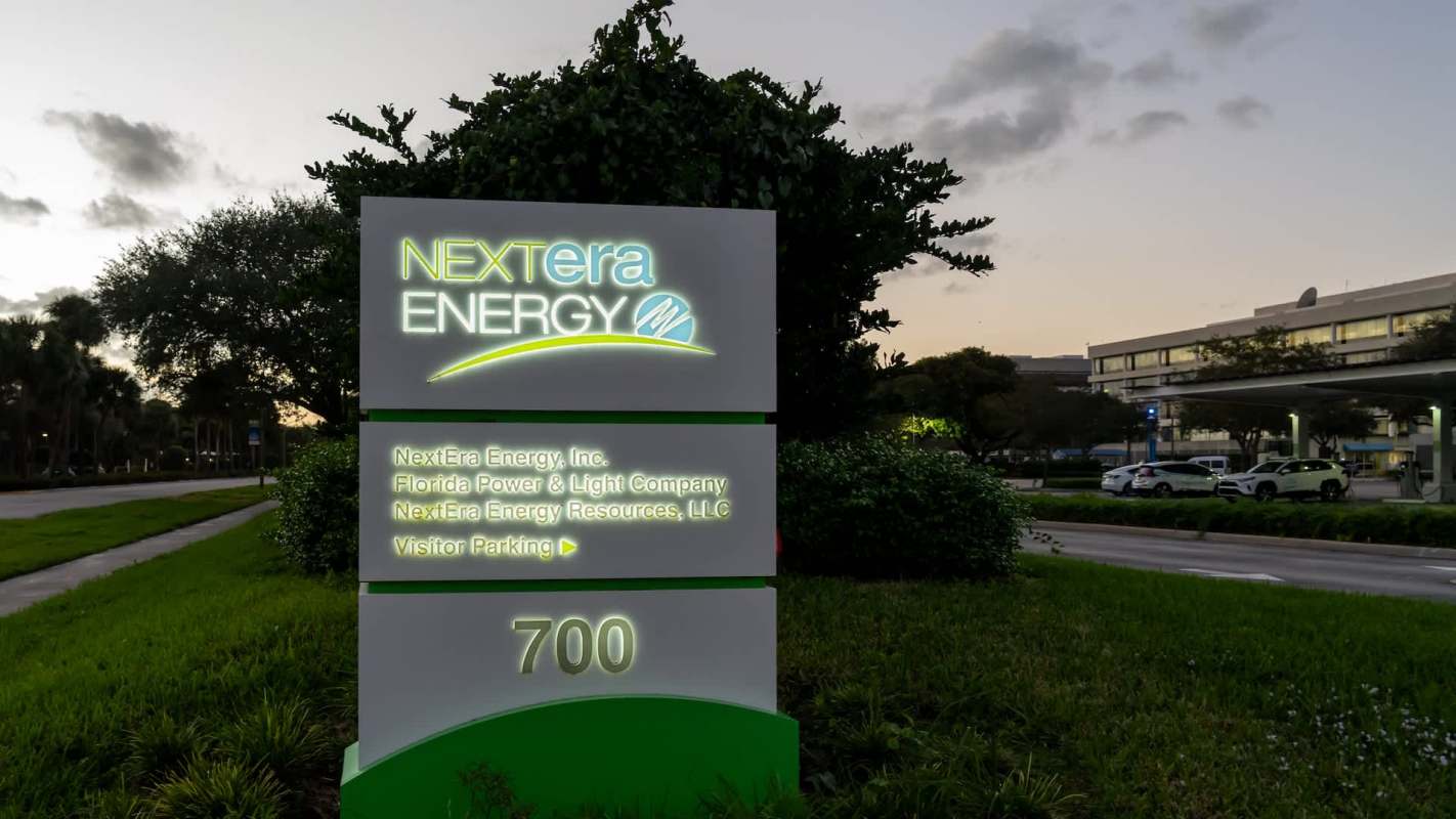A sign for NextEra Energy displaying company information and visitor parking details.