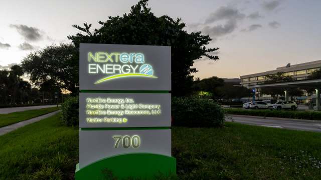 A sign for NextEra Energy displaying company information and visitor parking details.
