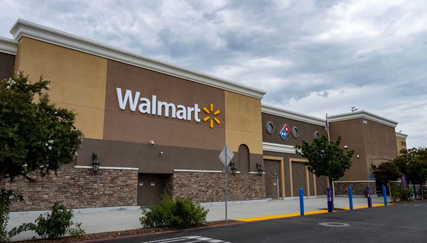 A Walmart store surrounded by trees and parking spaces.