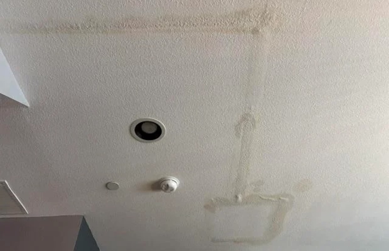 A ceiling with water stains and light fixtures.